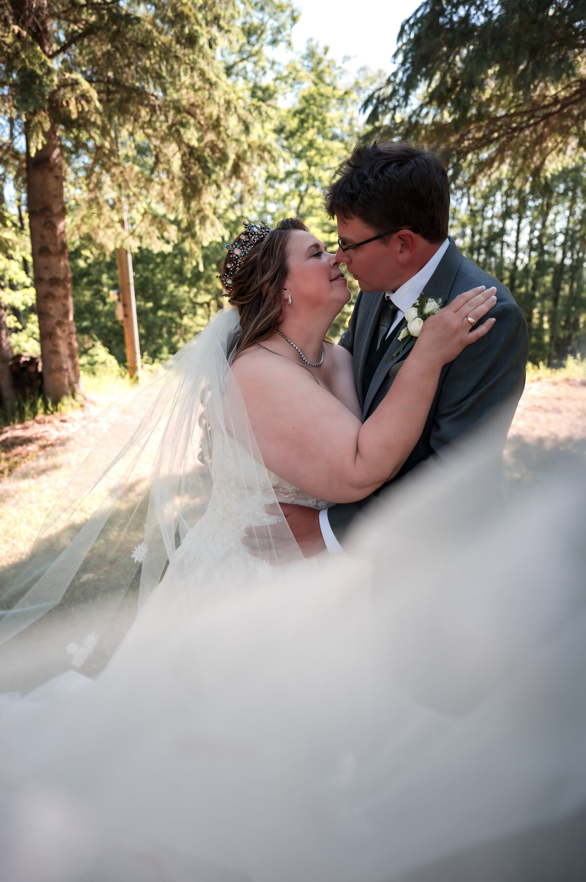 plus size bride cuddle up to her groom in romantic wedding photo