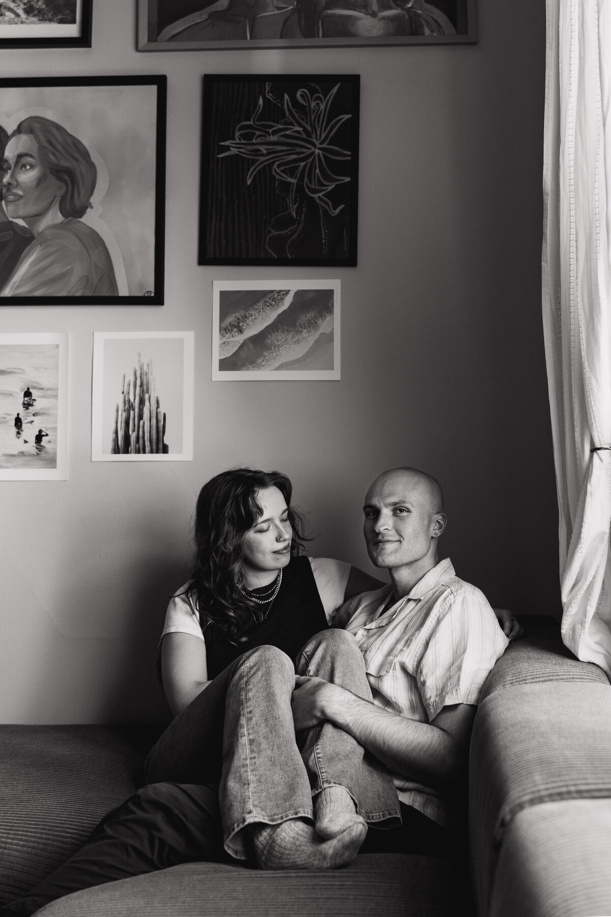 couple sits together on couch in home