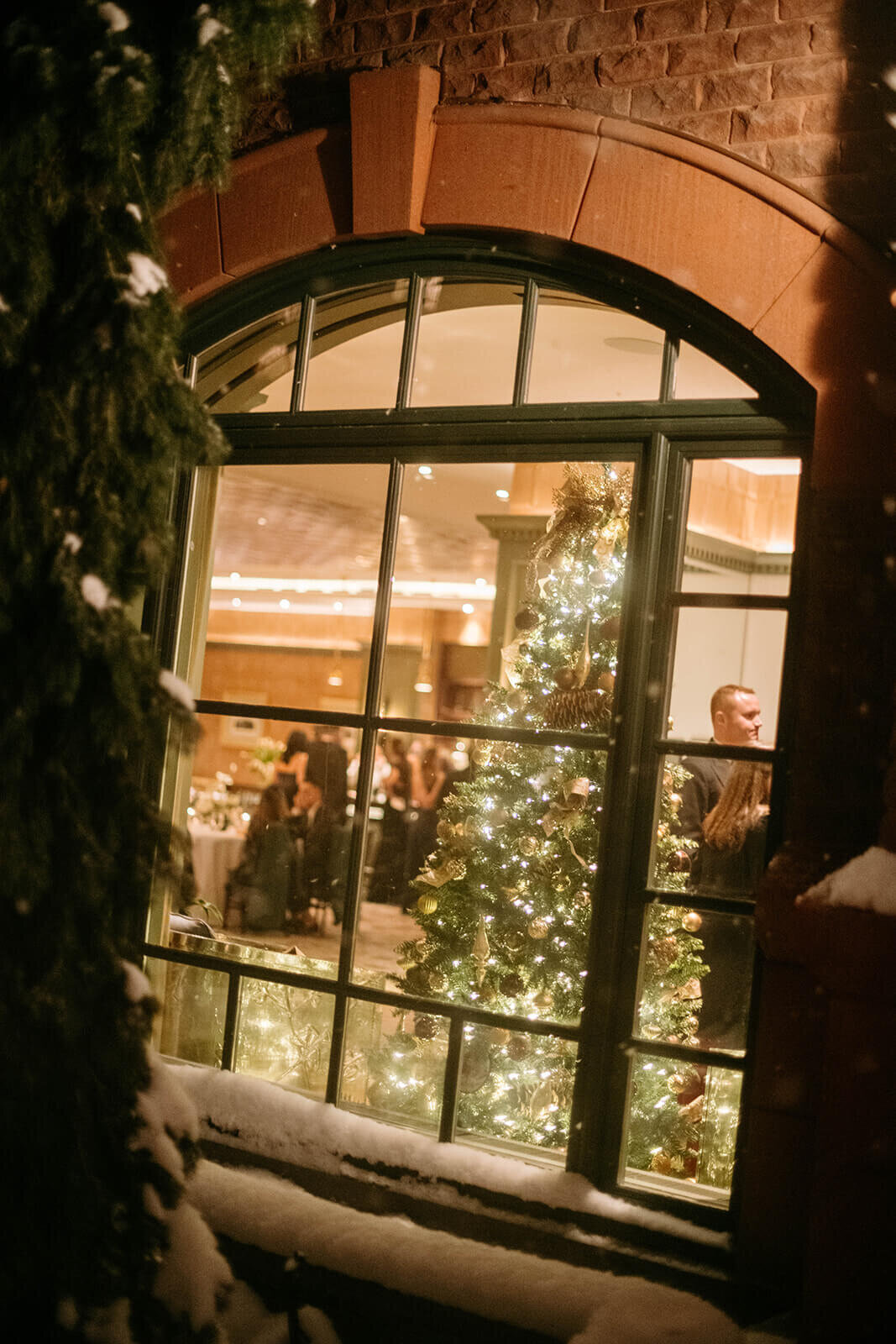 Sparkling view of the St. Regis Aspen wedding reception from the outside looking in through a window.