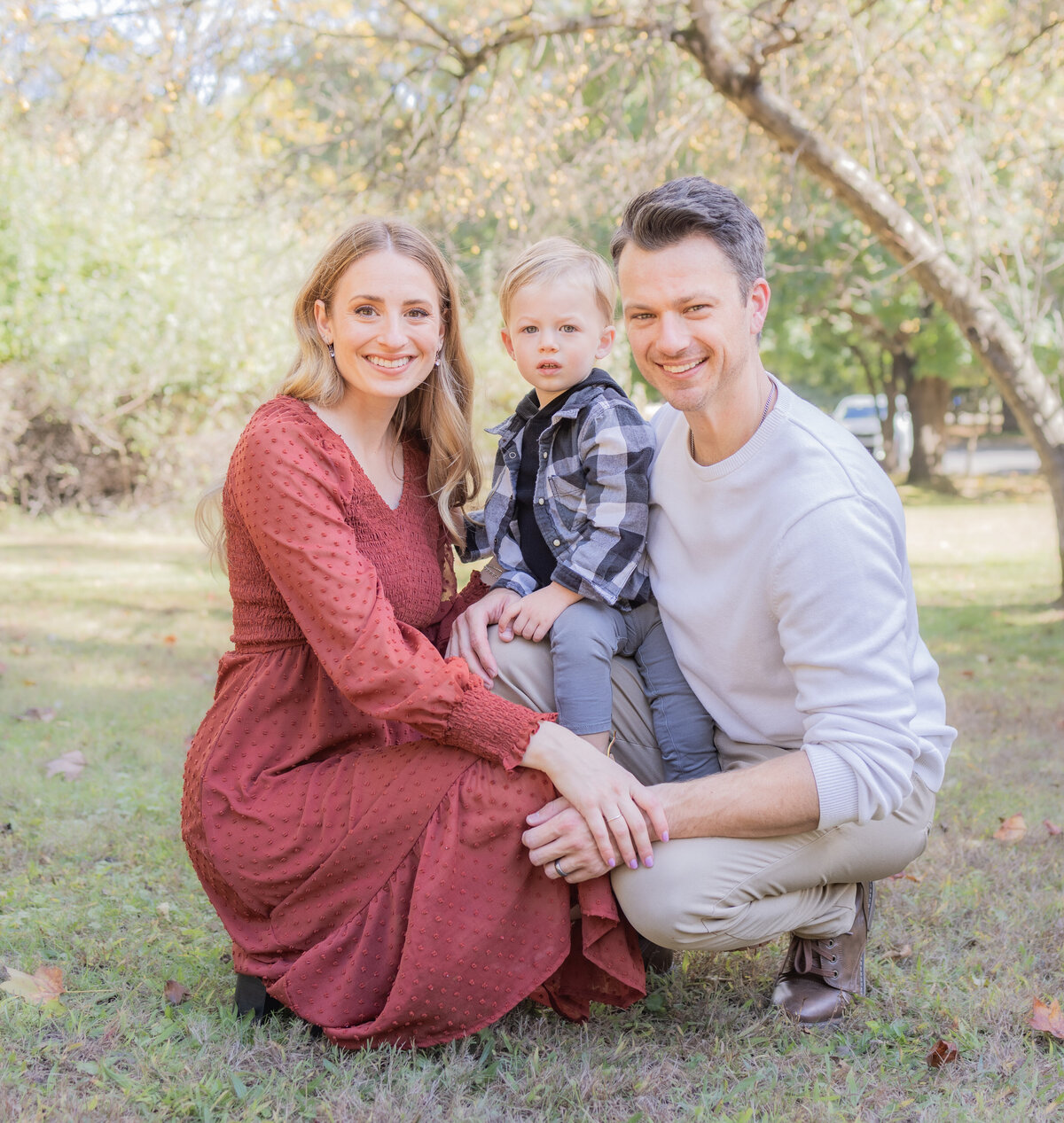 Mother, father, and child smiling during a fall family photography session in Bergen County