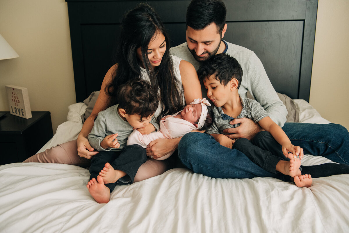 family on bed with baby  in-home  in Pensacola