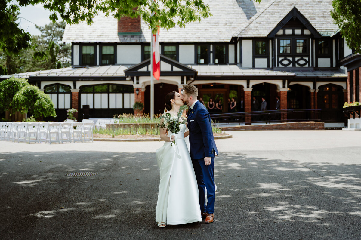 newlyweds-kissing-in-front-of-the-royal-ottawa-golf-club-in-aylmer-quebec
