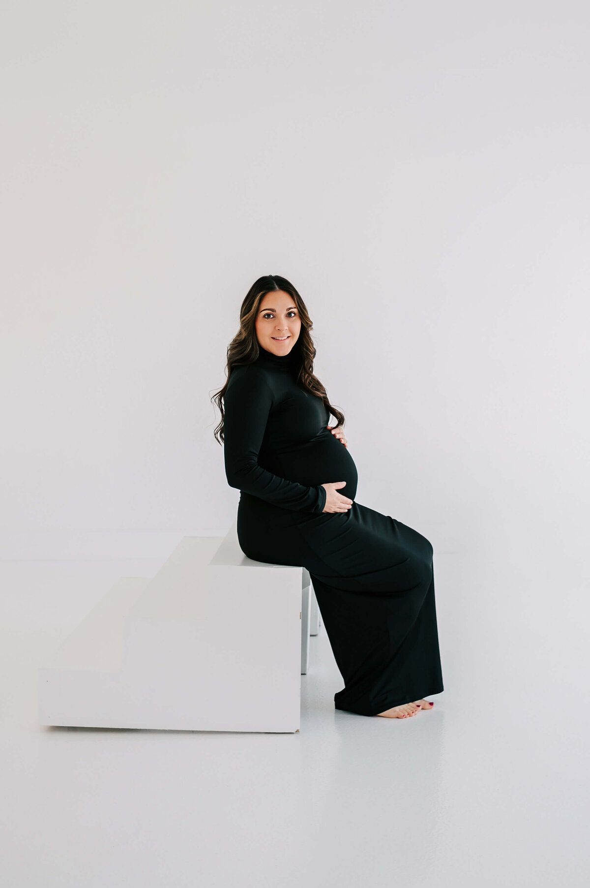 Joplin Mo maternity photographer Jessica Kennedy of The XO Photography captures pregnant mom in black dress sitting on steps
