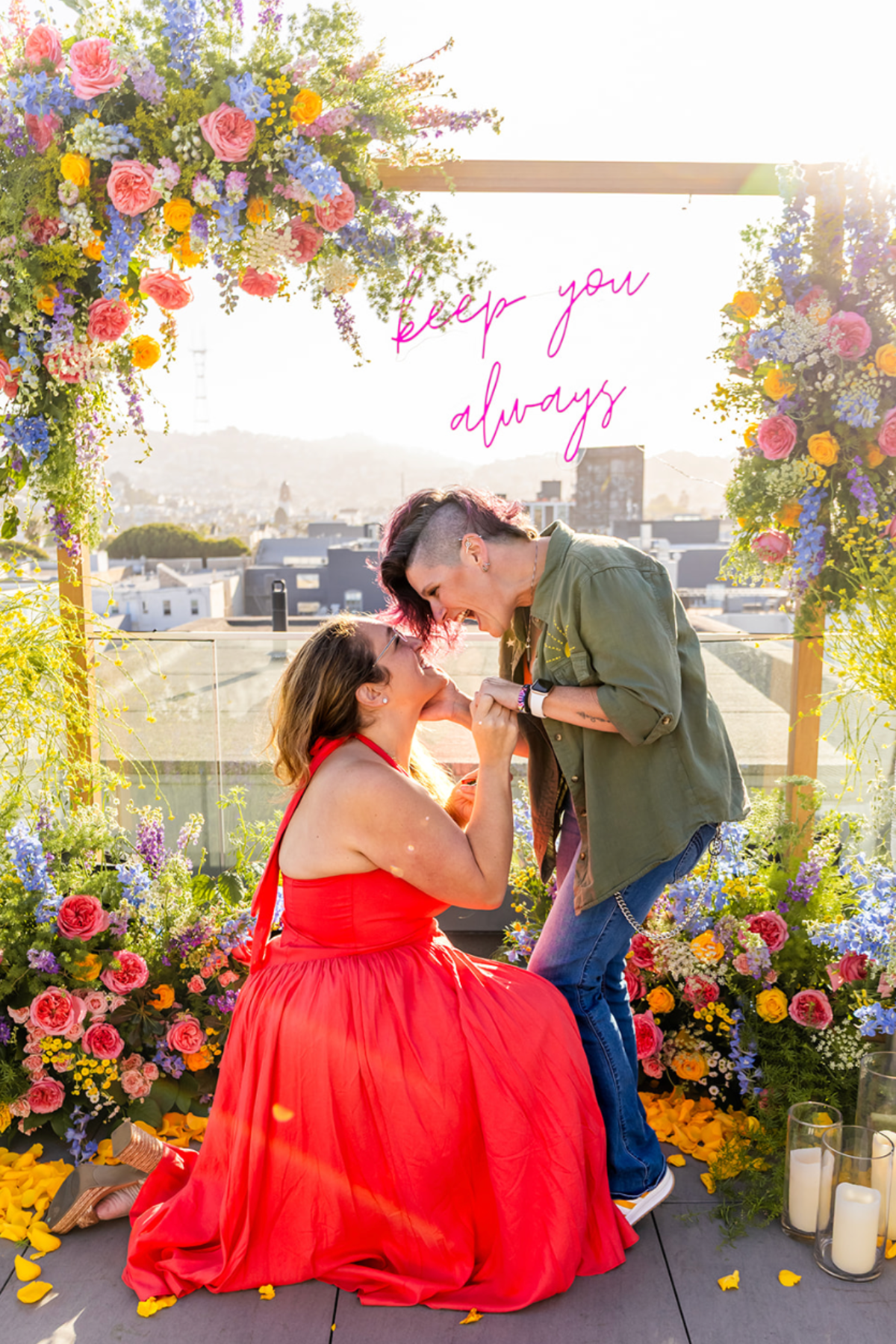 a lesbian couple does a surprise proposal surrounded by opulent florals on a rooftop in san francisco