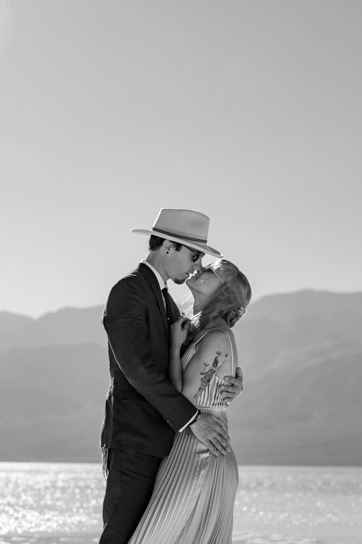A couple holding each other close as they lean in to kiss