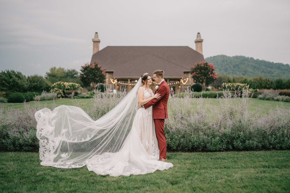 bride and groom stand in front of the winery captured by Washington DC wedding photographer at a winery in Northern Virginia