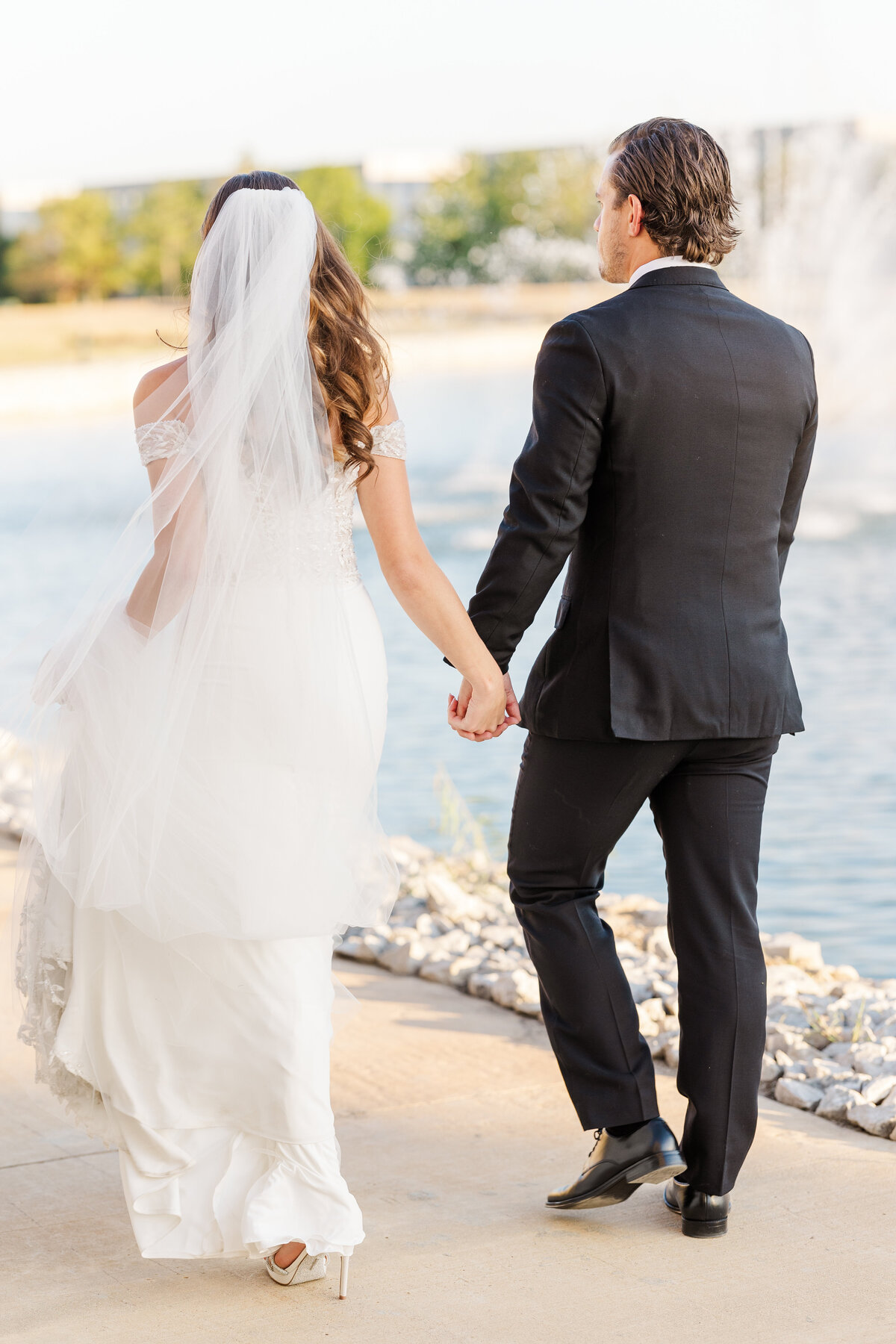 An intimate candid moment of the couple bathed in evening light, highlighting the bride’s beaded gown and flowing veil. Shot in Westlake, TX, serving the greater Dallas-Fort Worth area.