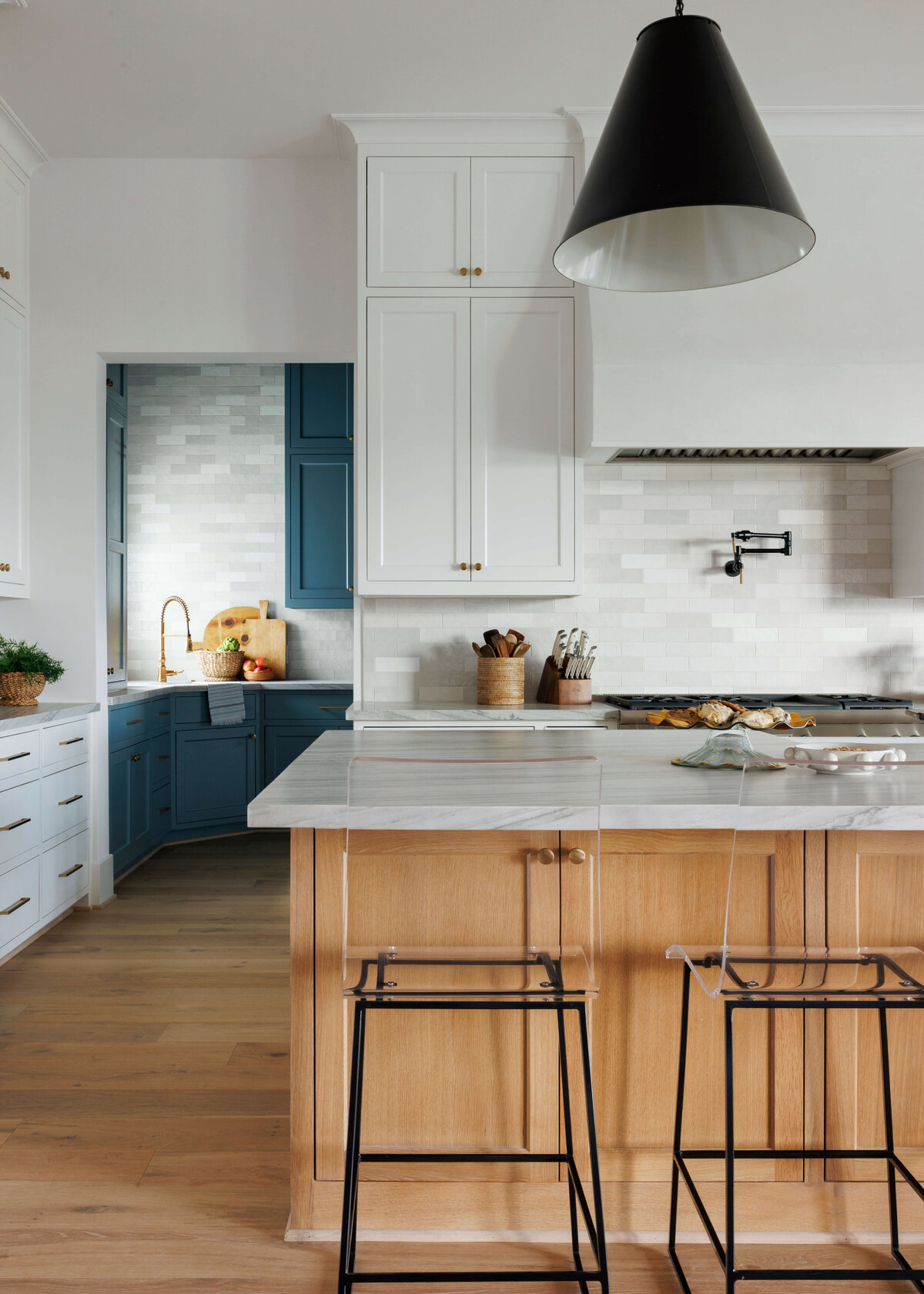 oyster creek studios missouri city new build wooden cabinets and marble counters with black wire stools in kitchen