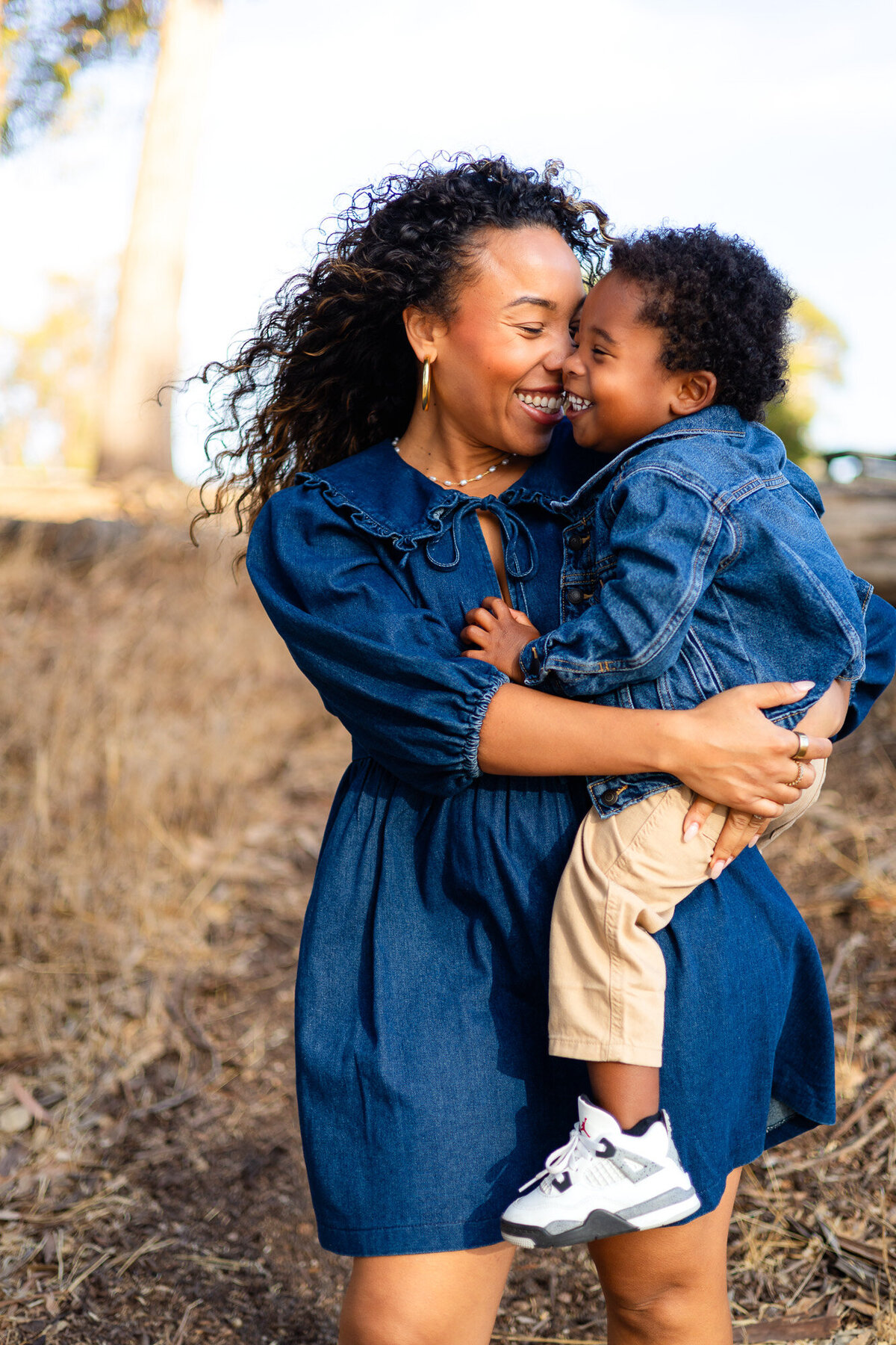 Mother holding young son close while smiling outdoors, Bay Area Family Portfolio – Ellobelle Photography