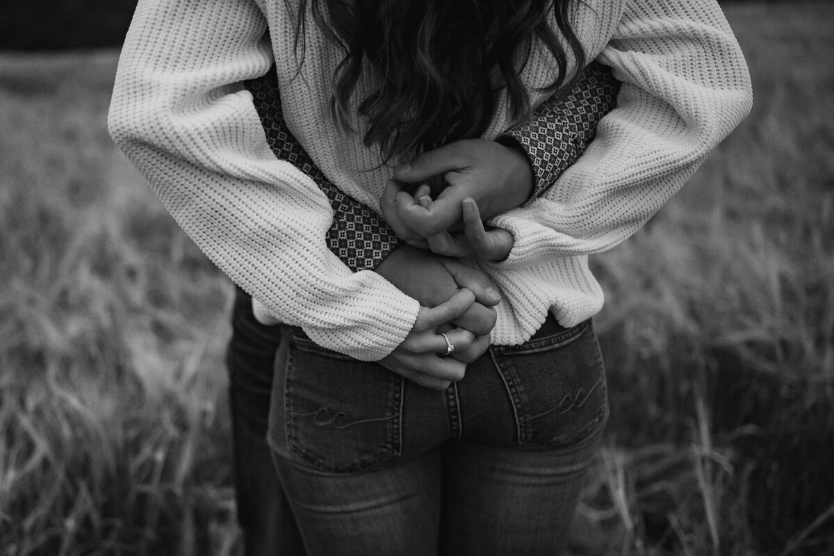 Black and white photo of couples hands and the engagement ring