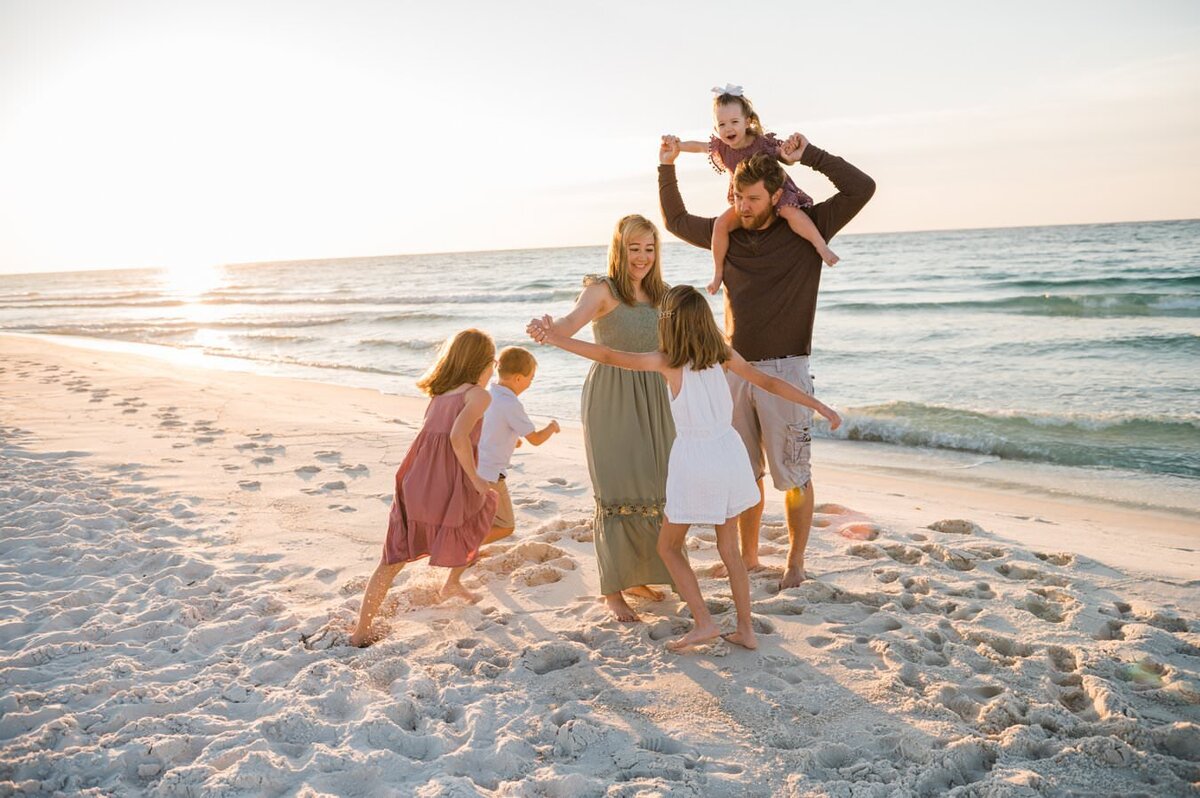 family running at playing on beach in Pensacola