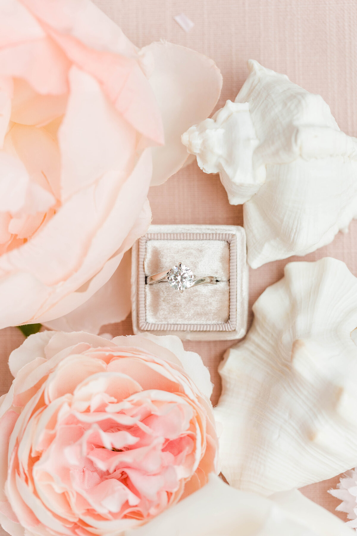 engagement ring surrounded by pink flowers