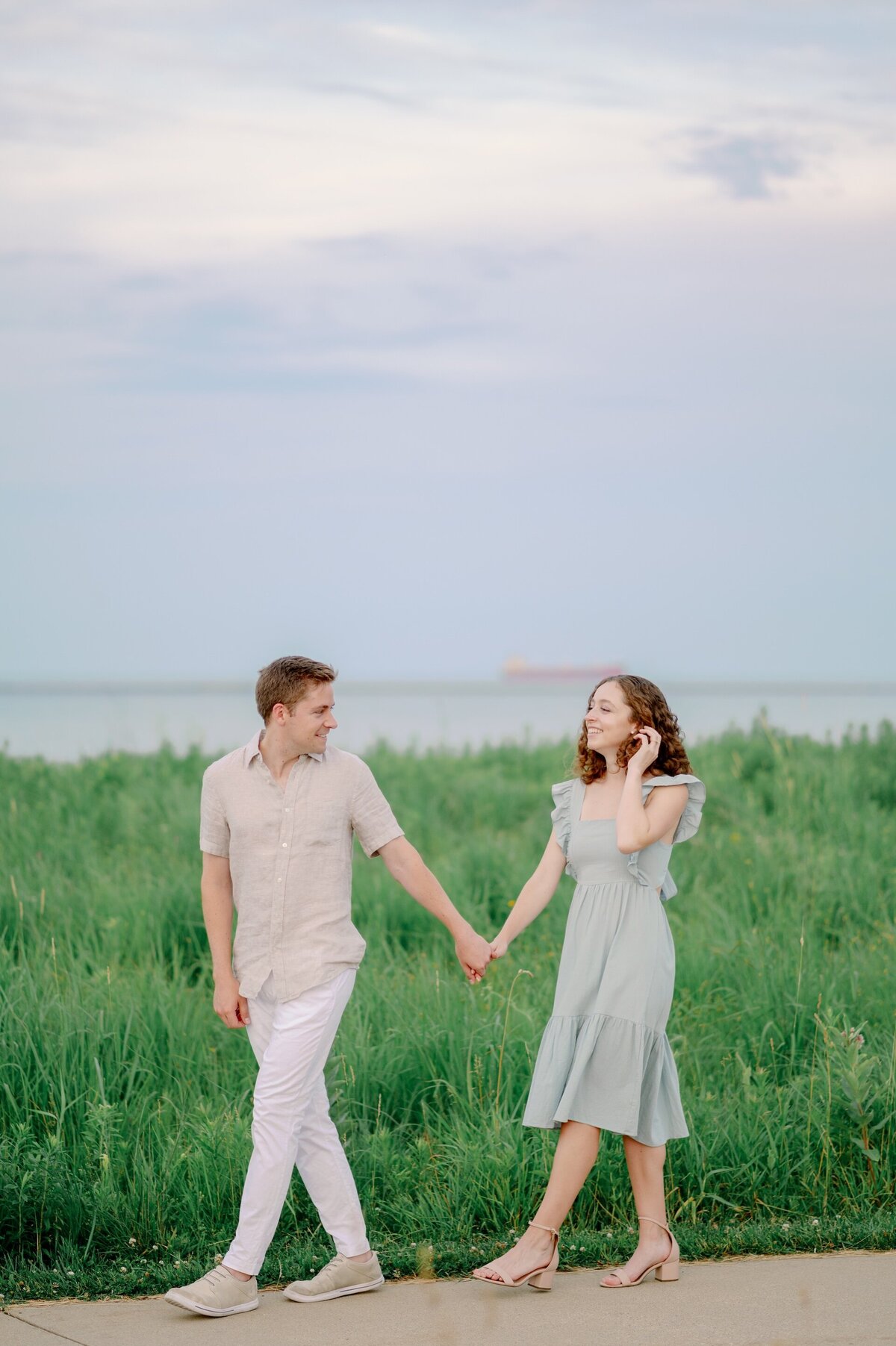 couple holding hands while walking on a trail