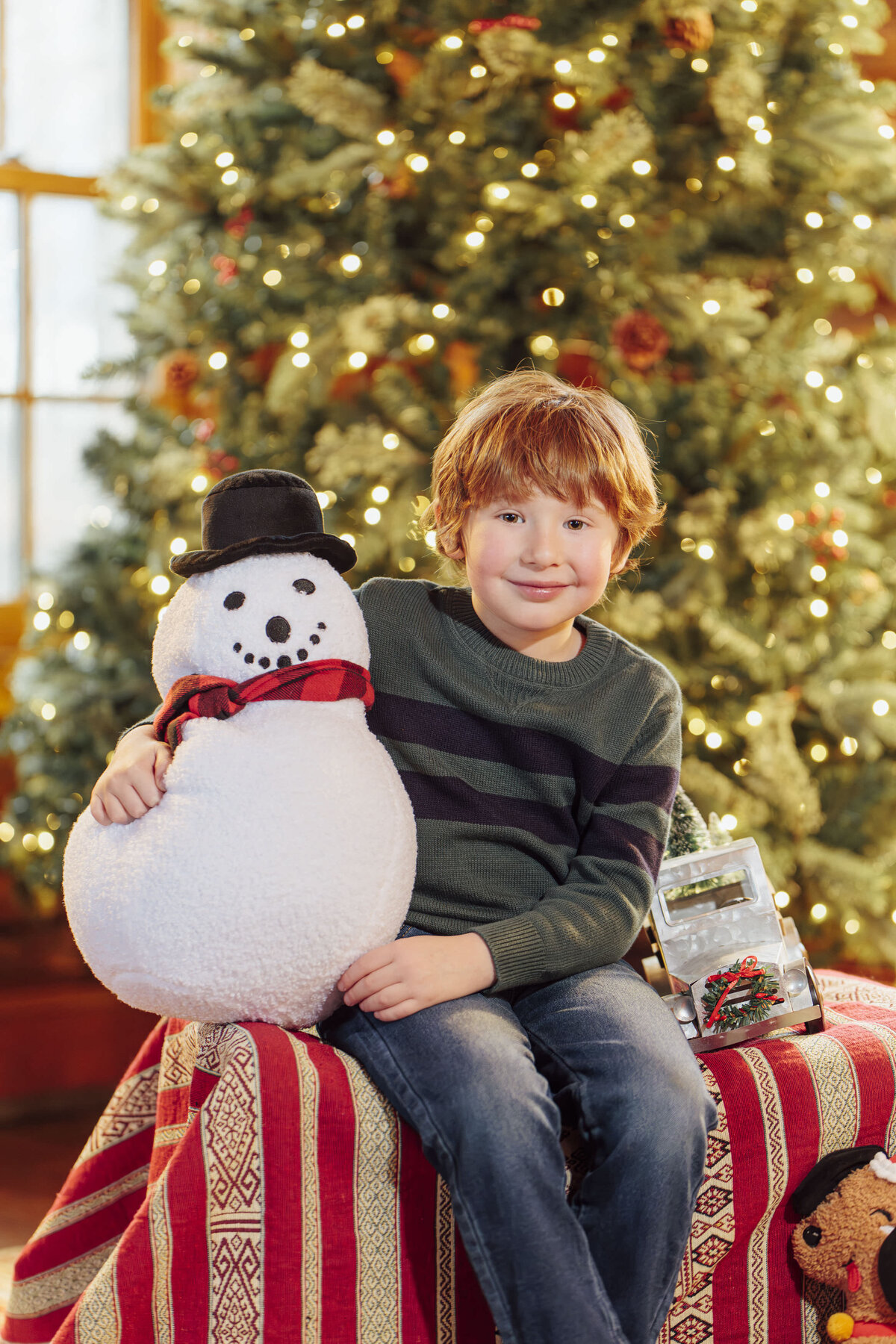 Family Portraits | Family posing beside a decorated Christmas tree during a winter holiday session | New Jersey