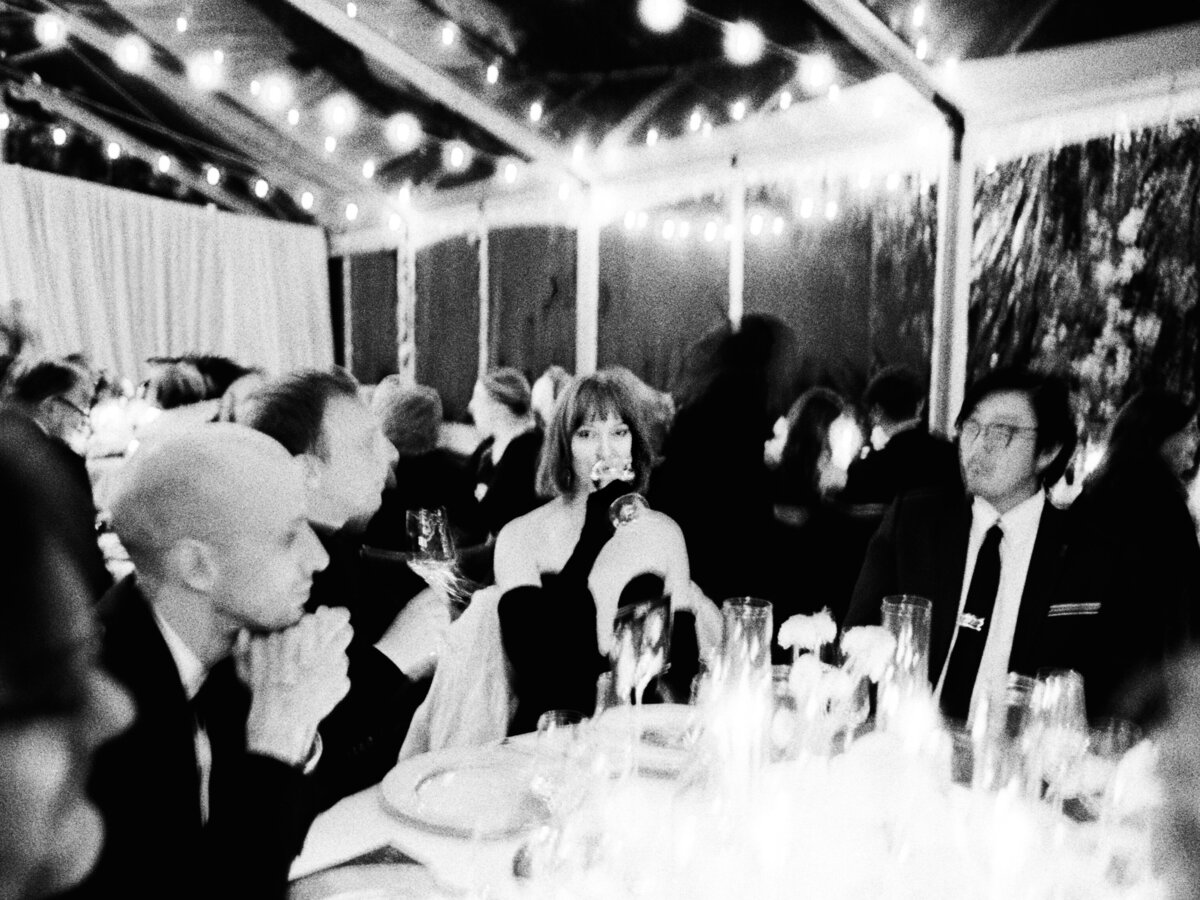 A timeless black and white film photo of a guest savoring dinner, evoking nostalgic warmth and realness, captured by Kate Winters Photography
