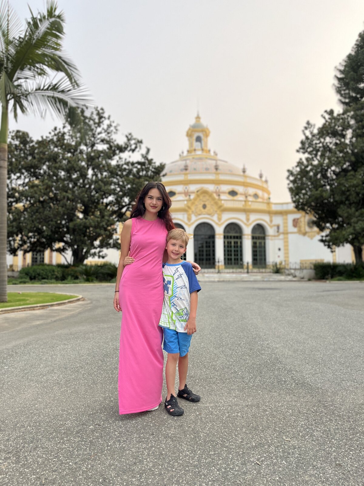 Sonia posing with her son in front of a building with ornate architecture