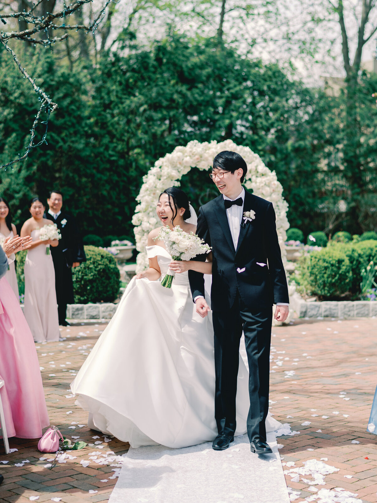 Bride and groom holding hands down the aisle smiling and happy