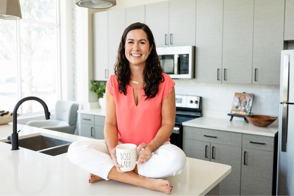 Angie seated on the countertop with a mug, ideal for personal branding and lifestyle content. Perfect for showcasing relaxed moments and daily routines in a brand photoshoot.