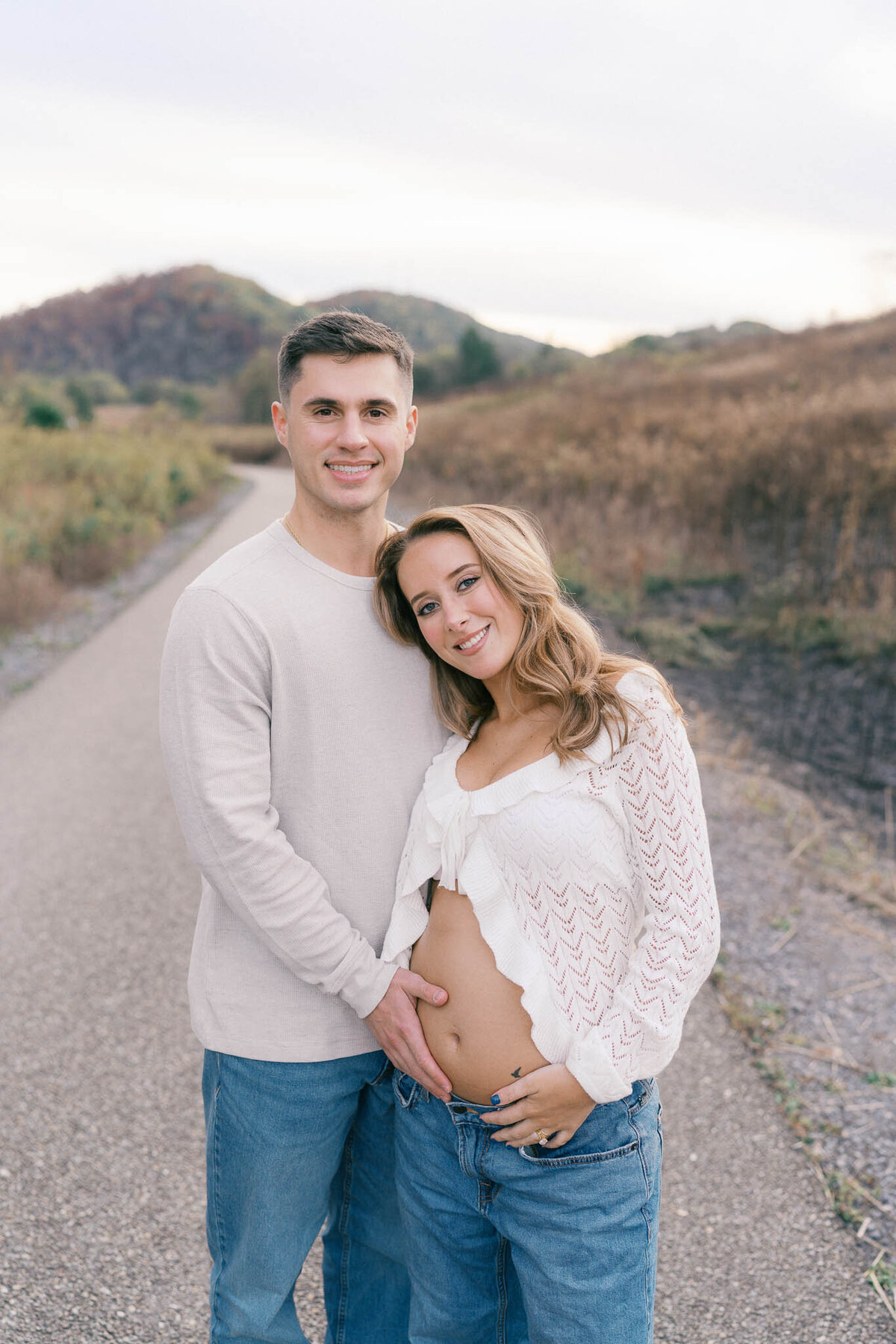 man holds pregnant woman's belly in front of mountain at seven islands park in kodak tennessee