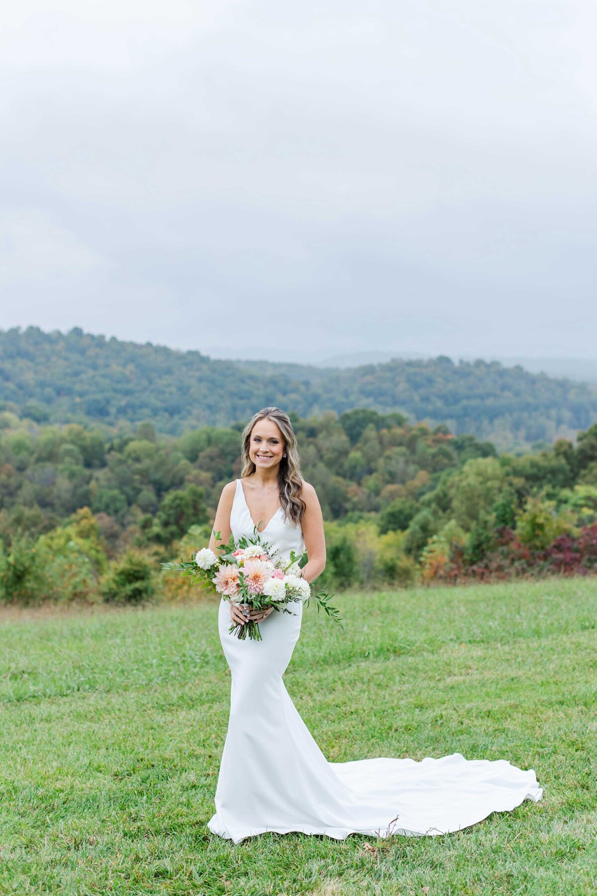 Bride wearing made with love wedding dress holding flower bouquet at chateau selah blountville tn