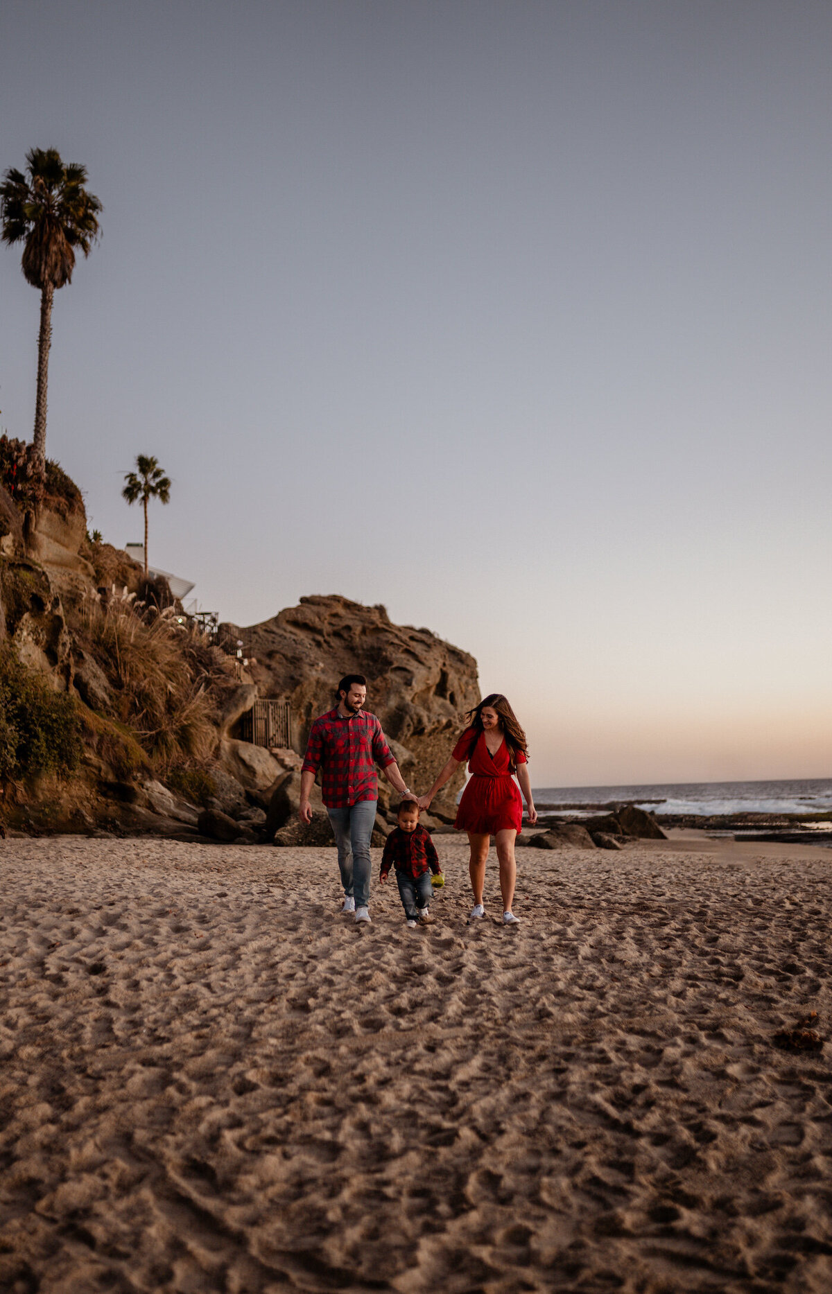 Mom Dad and Baby walking along beach in La Jolla California for photoshoot