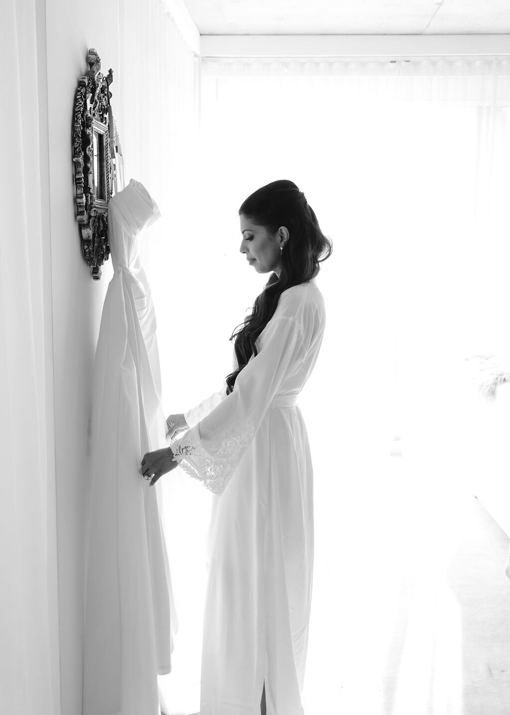 Bride admiring wedding dress in Public Hotel suite in NYC