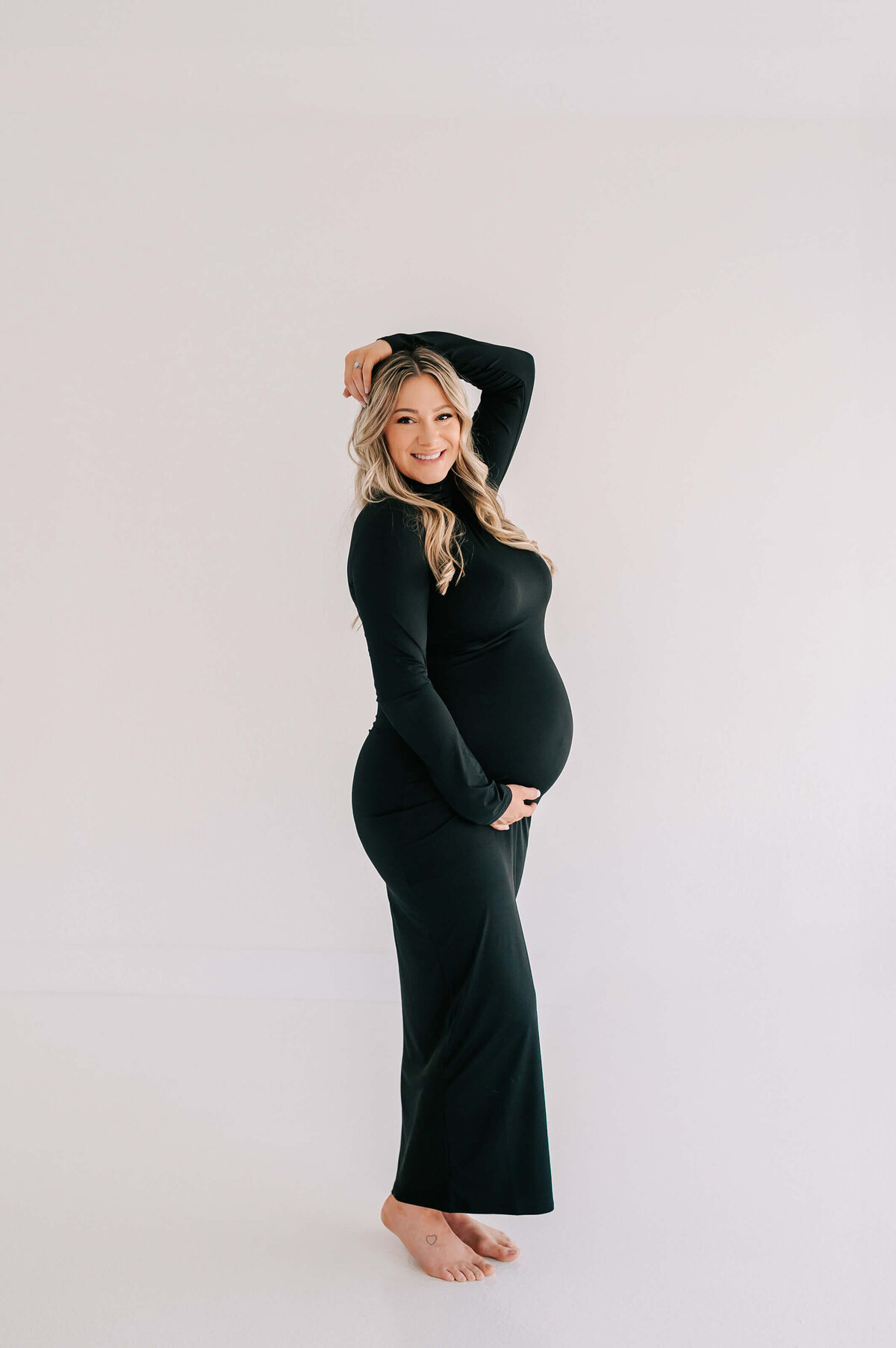 maternity photo in Branson Missouri of mom in black dress smiling