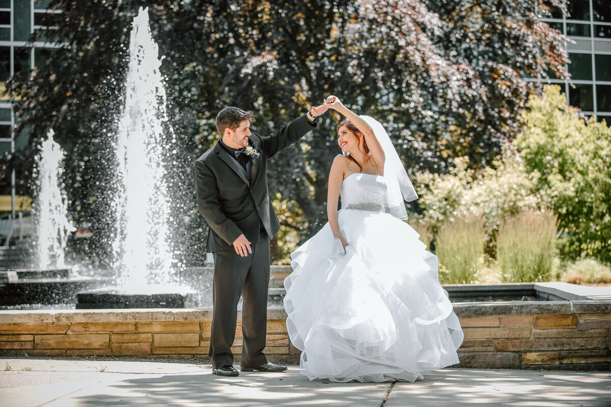 Newlyweds dancing by a fountain with a Michigan wedding photographer
