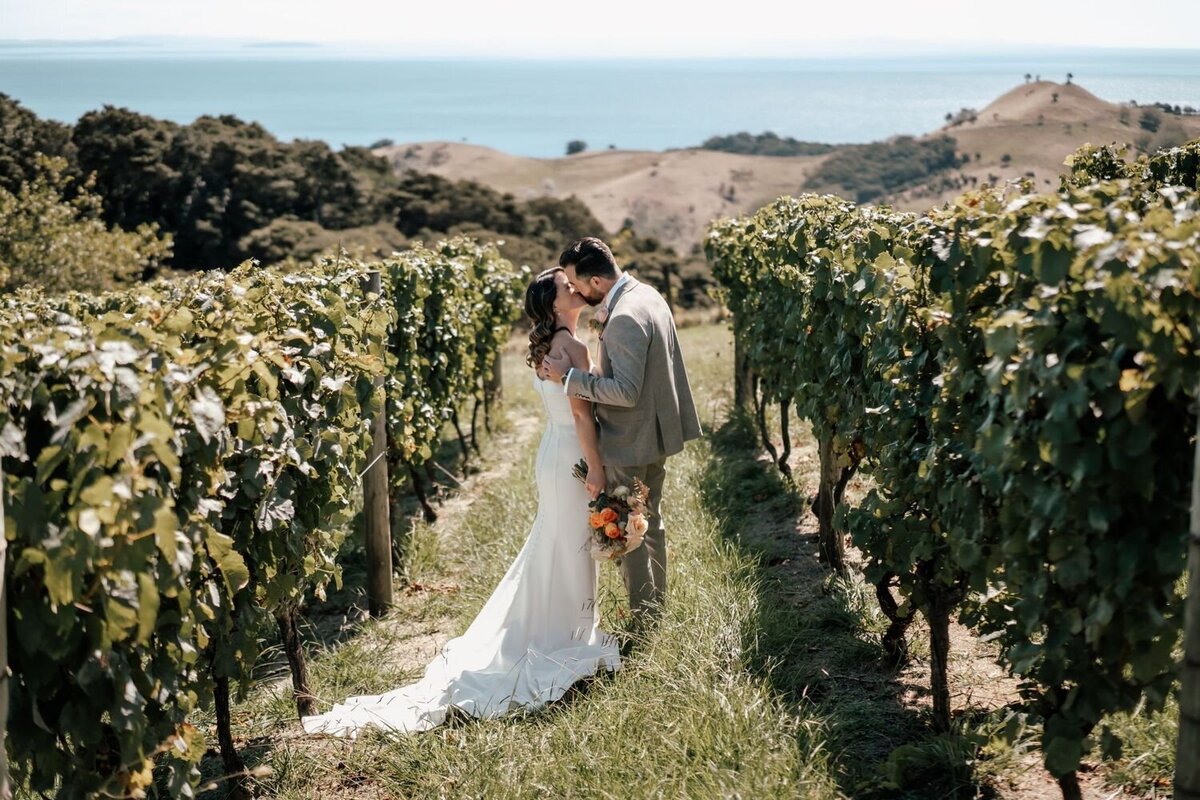Bride and groom Lorna and Will walking outdoors surrounded by nature during their Waiheke Island wedding portraits, photographed by Zanthe Vorsatz.
