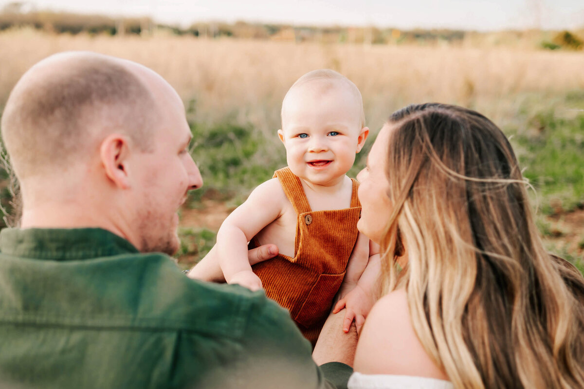 family photo of baby boy smiling with parents during Springfield MO family photography session