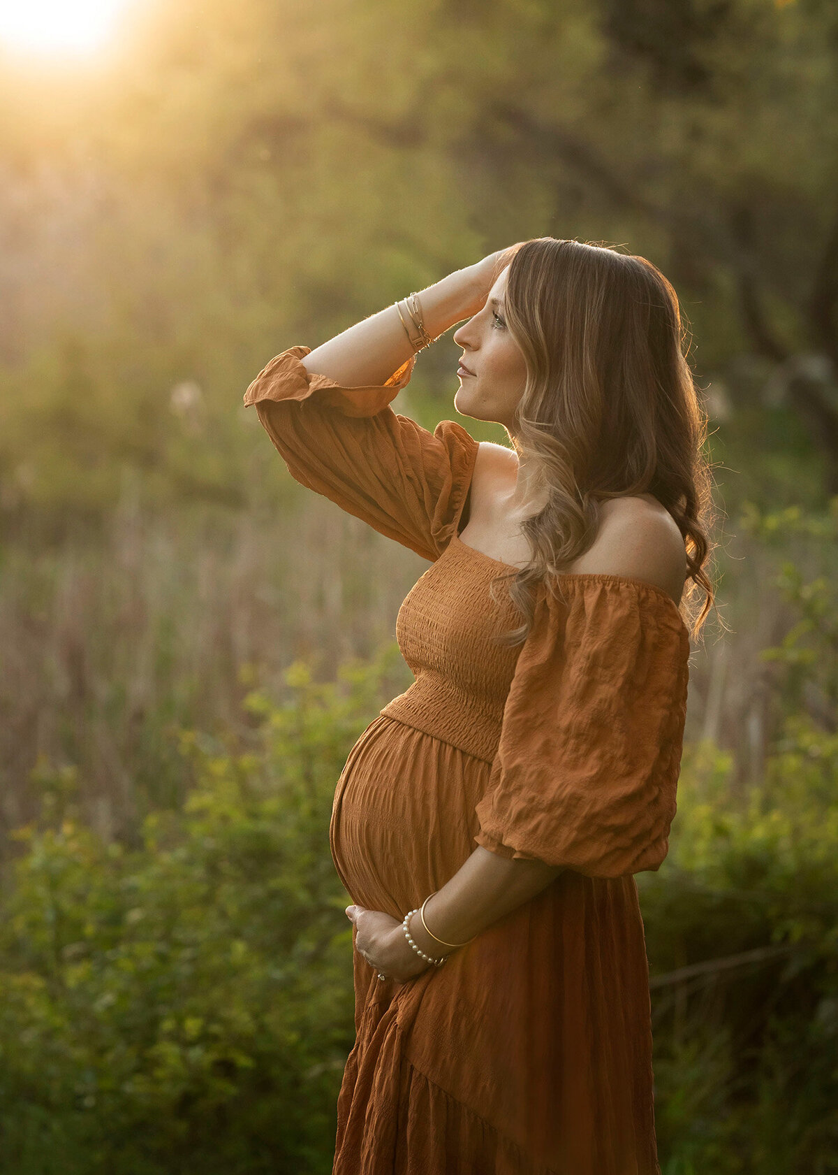 NJ Maternity Photographer captures mom holding her body while in a golden glow
