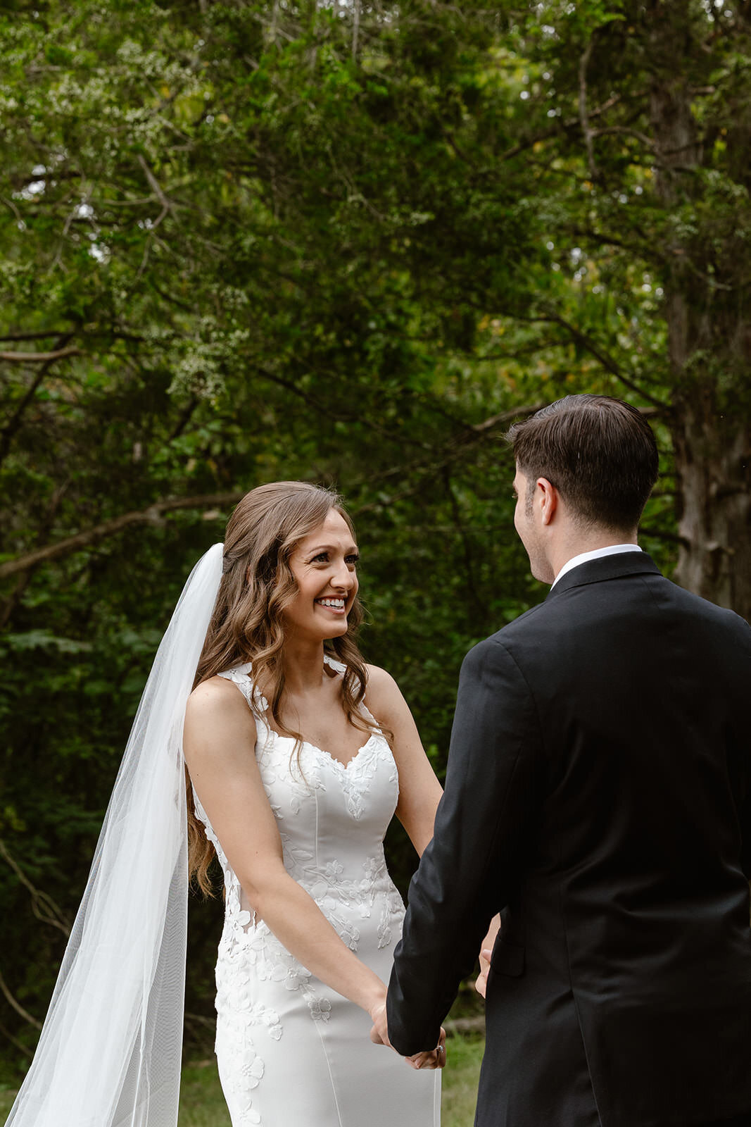 A person smiling in a wedding dress during their wedding ceremony