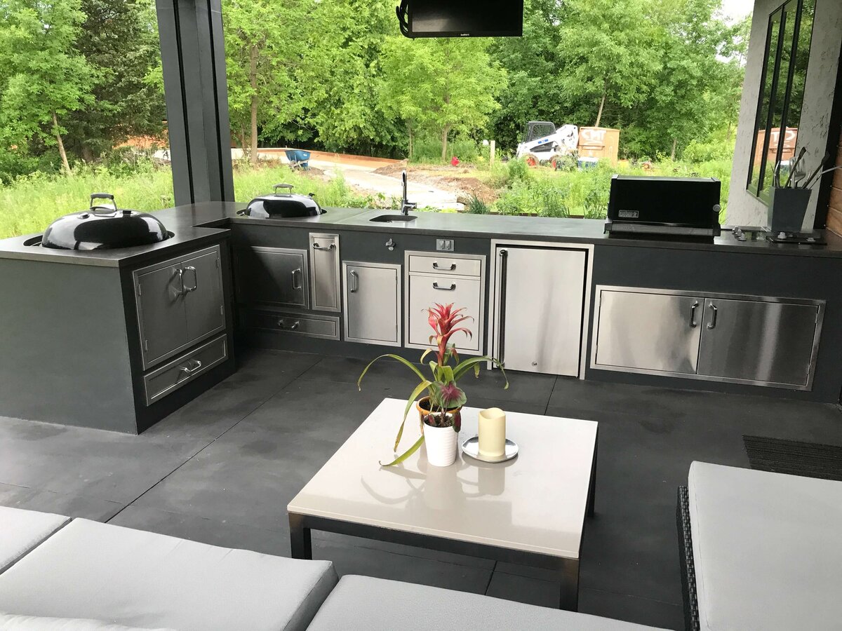 Concrete countertop in outdoor kitchen with cutouts for sink and grills