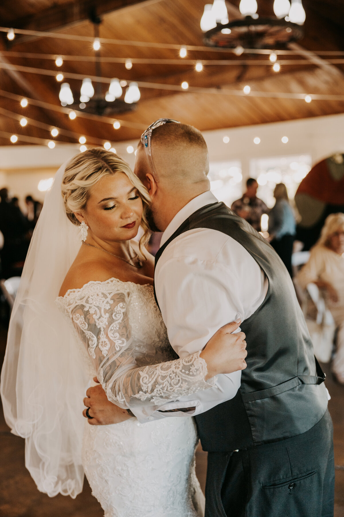 Bride and groom holding each other close during their first dance at their wedding in Millington, Tennessee.