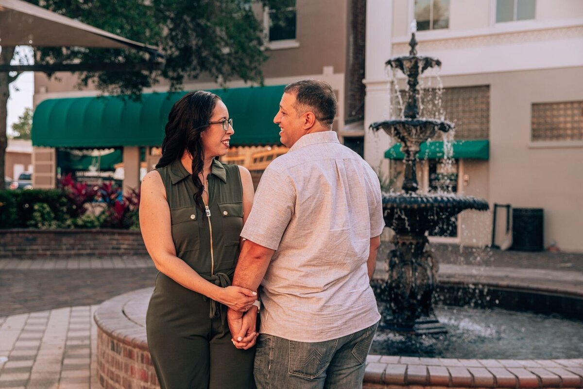 sanford florida engaged couple smiling at eachother in front of a fountain
