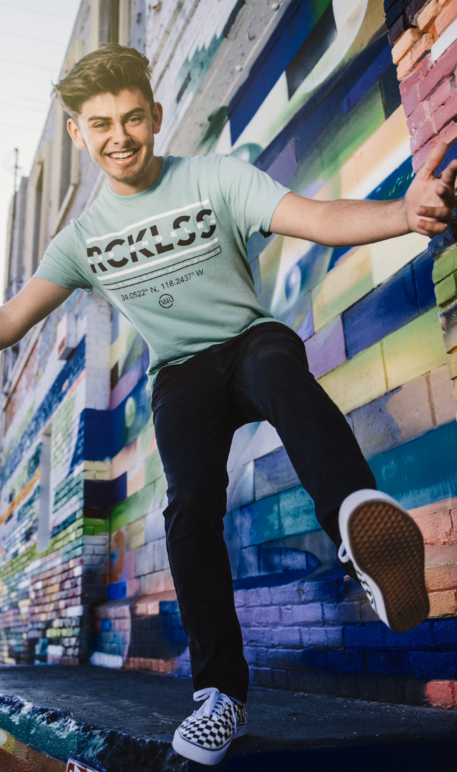 boy jumping off a colorful wall in a blue tshirt in dtla