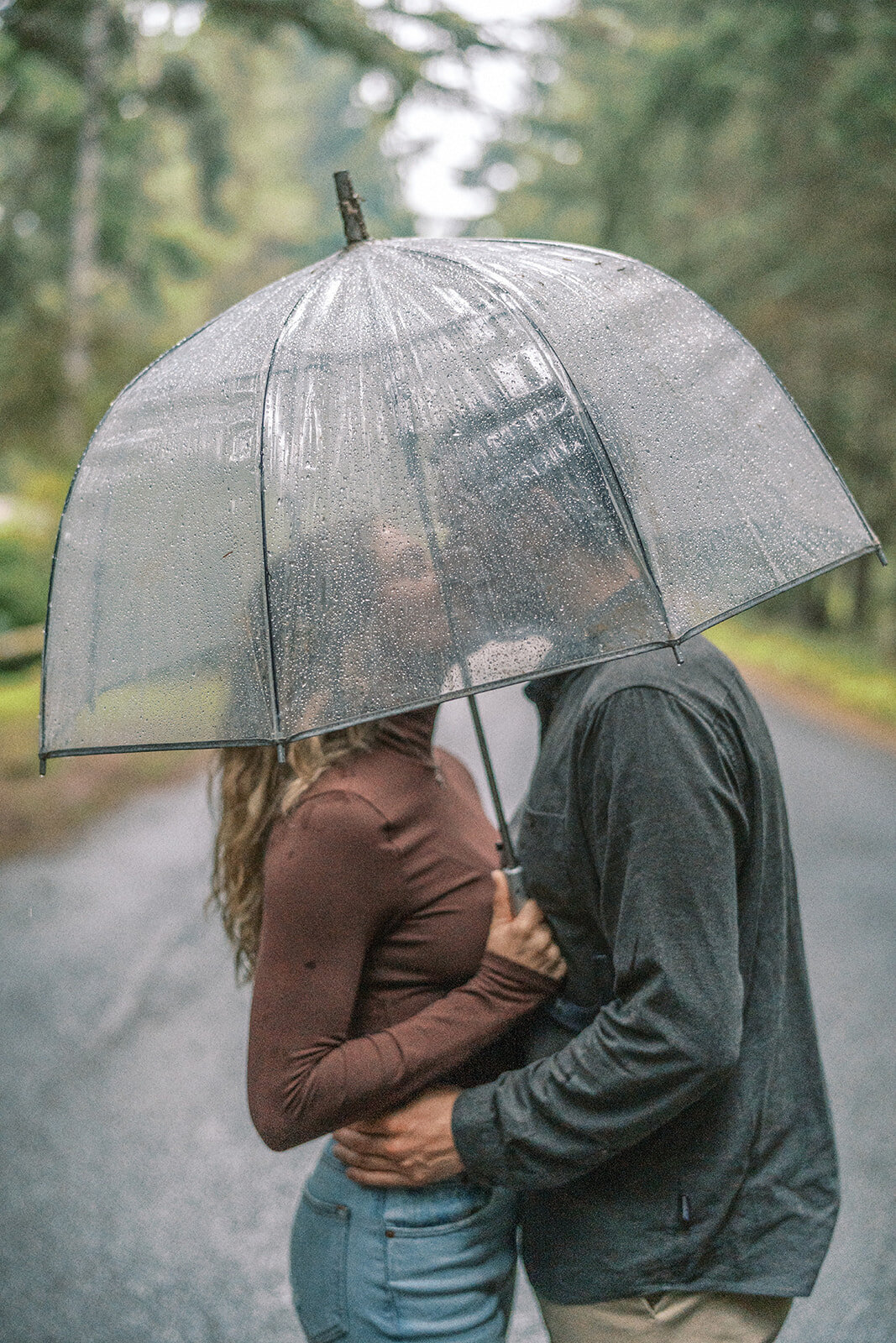 A couple kissing under an umbrella. 