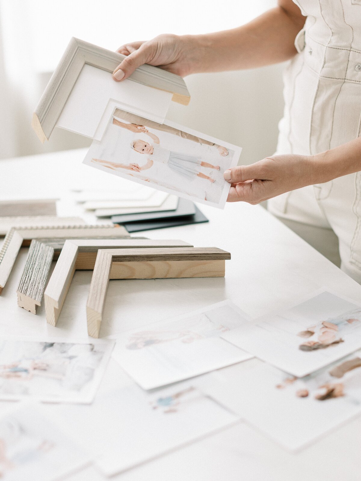 Neutral flatlay of linen albums and framed fine art prints – Charlotte custom photography products