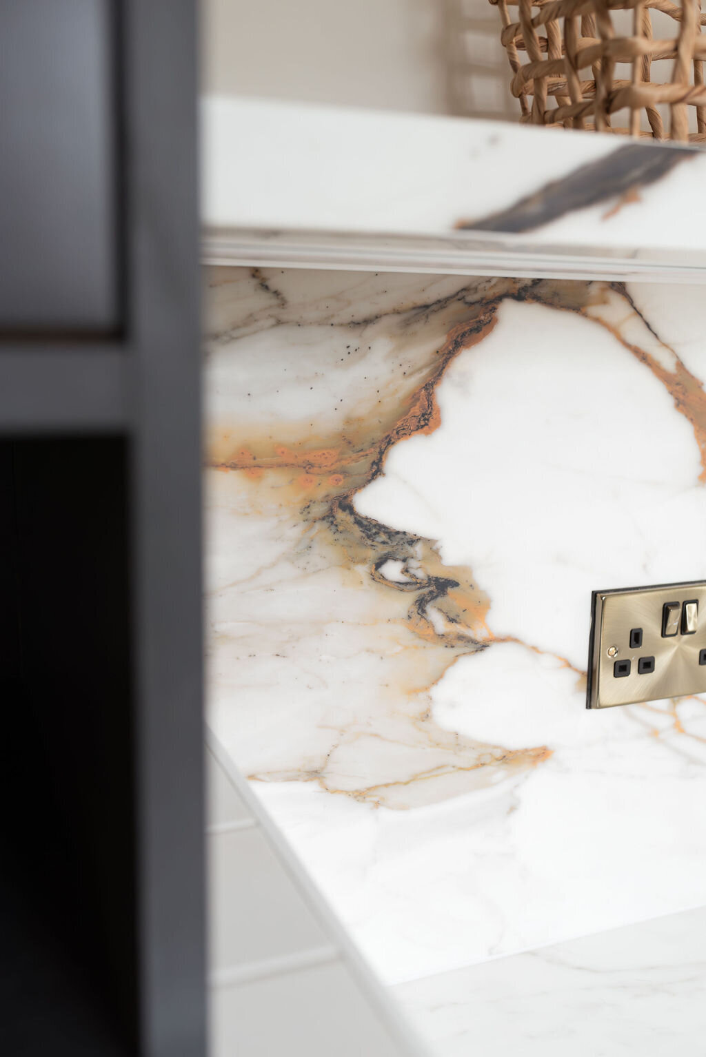 Close-up look at white marble counters, veined with black, grey, and brown.