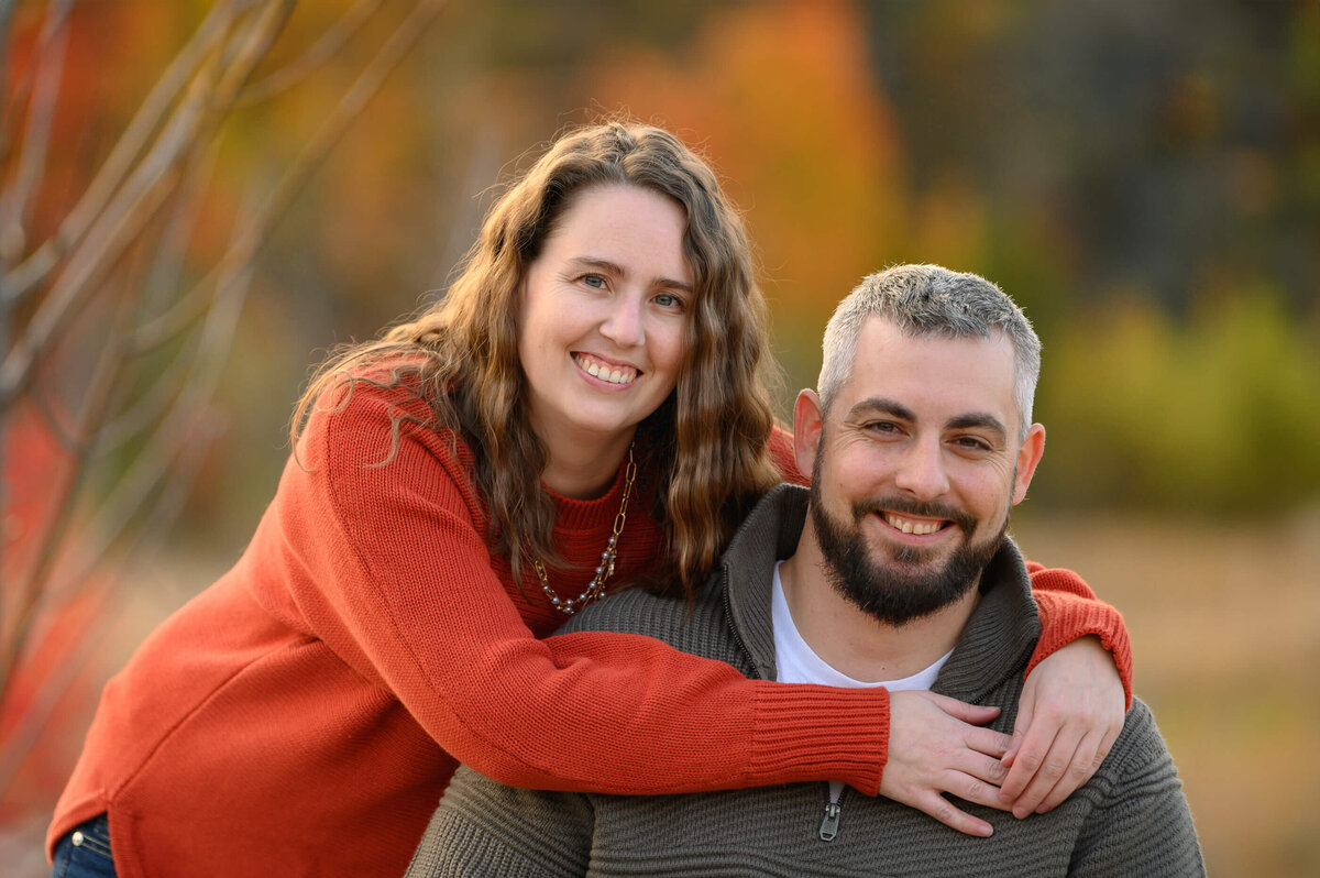 upclose photo of husband and wife.  wife's arms around husband neck who is in a wheelchair for their fall family photos in Burlington, ON