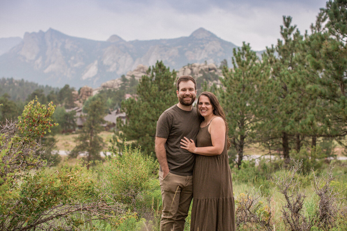A couple in green smile for the camera in Estes Park, Colorado