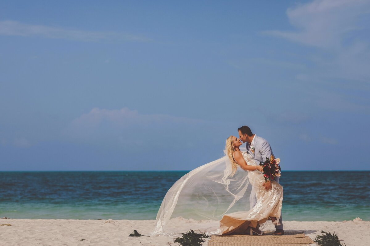 Groom kissing bride after wedding in Cancun