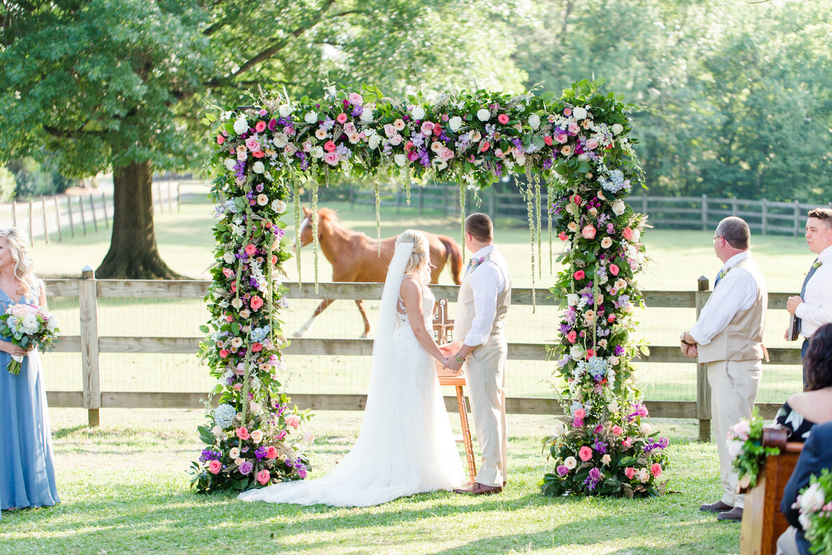 Wedding ceremony in front of field of horses