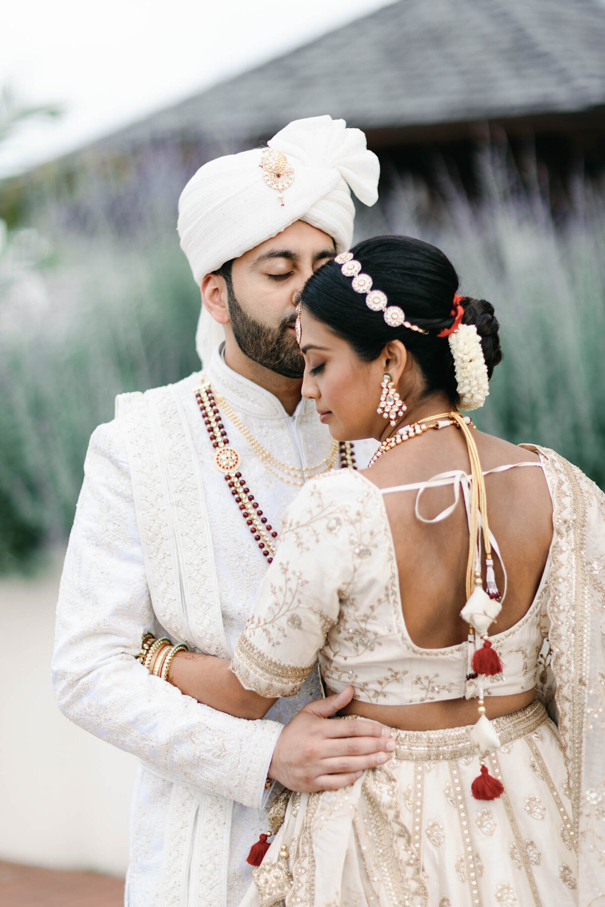 A film image of a modern  Indian American couple wearing white Indian clothes embracing  on their wedding day in the Baltimore Harbor.