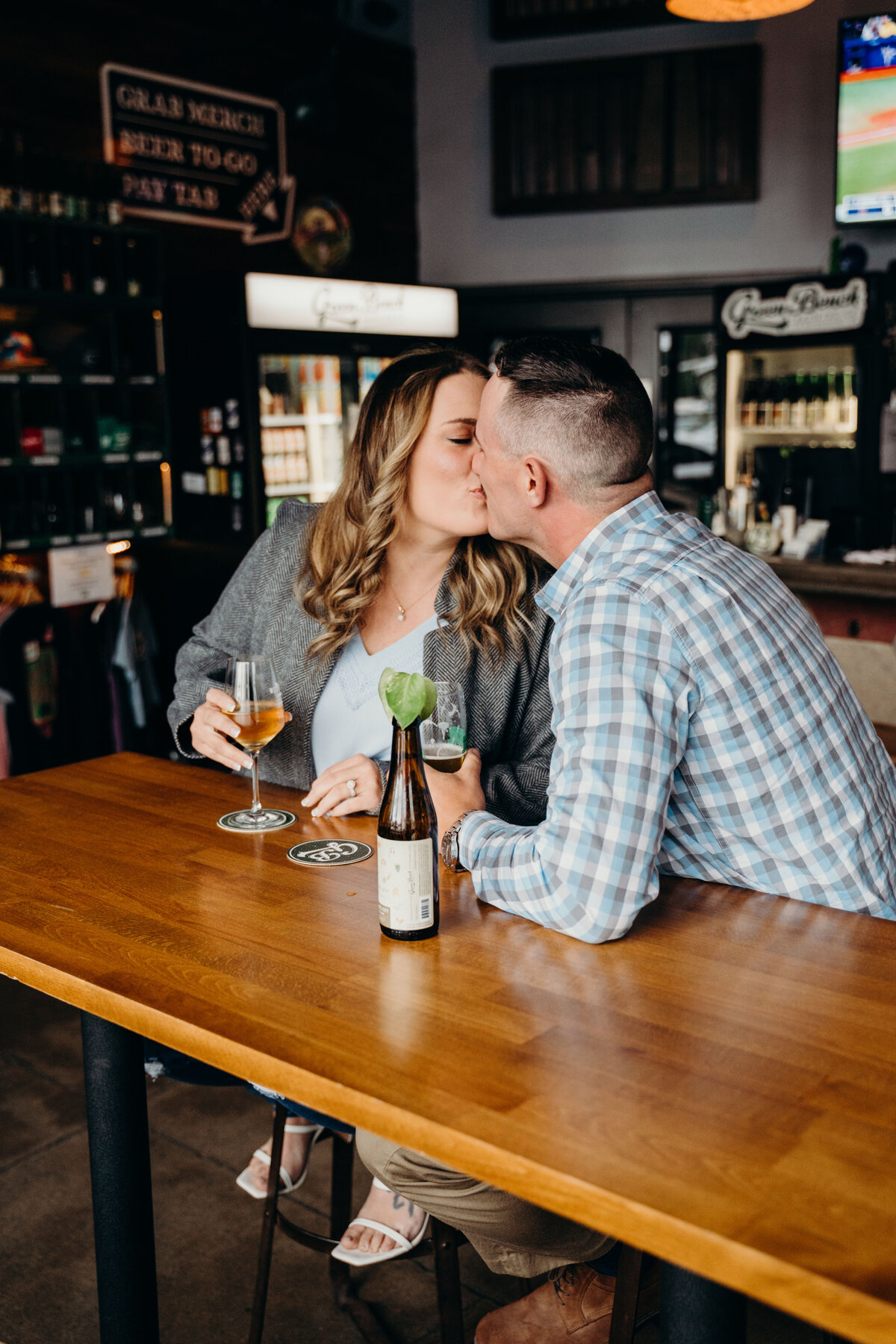 man and woman kissing at brewery in st pete florida during engagement session