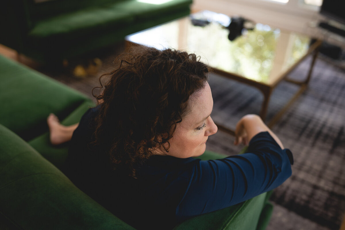Photo of a woman's side profile while sitting on a couch