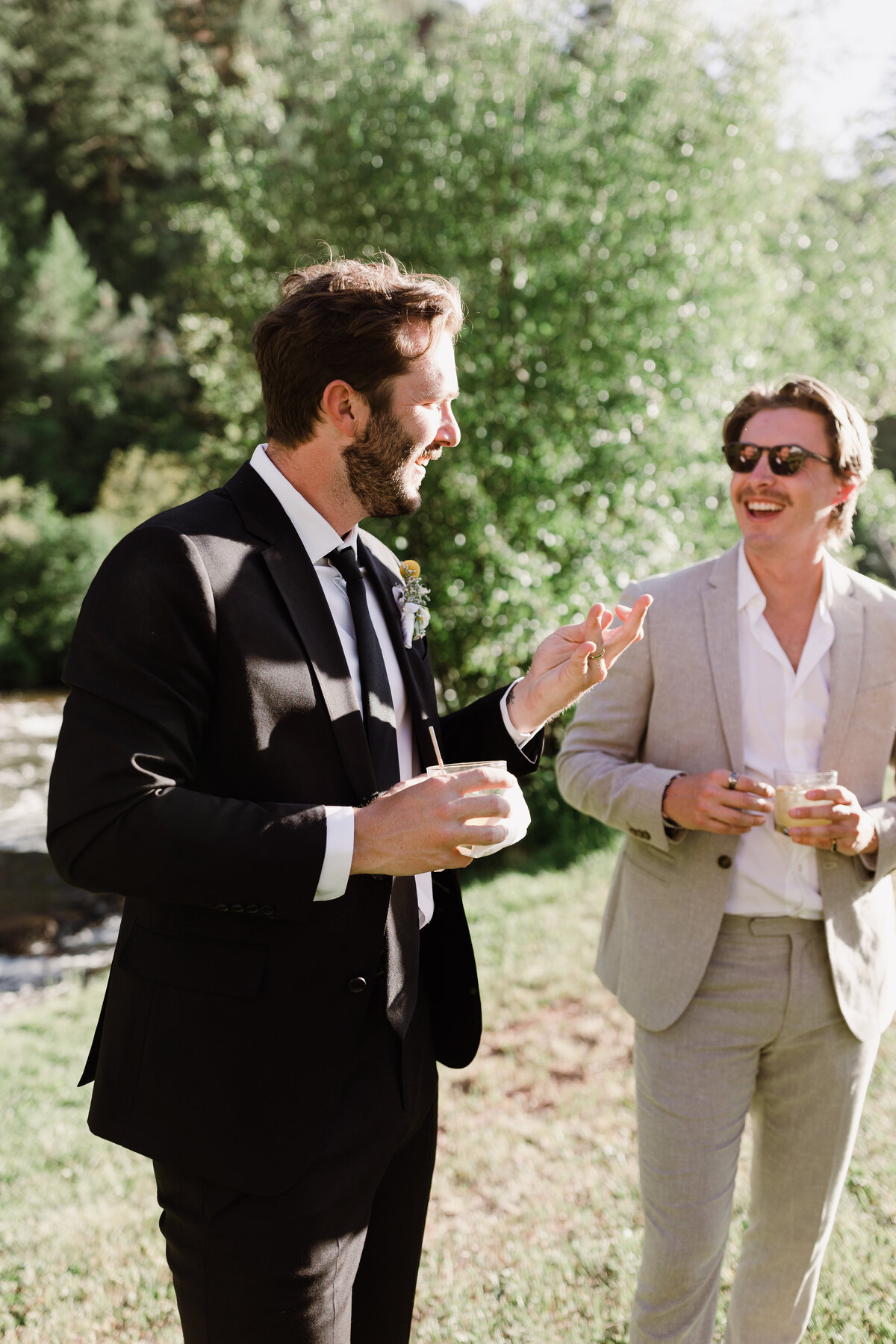 Groom chatting with groomsmen at Dallenbach Ranch Colorado Wedding