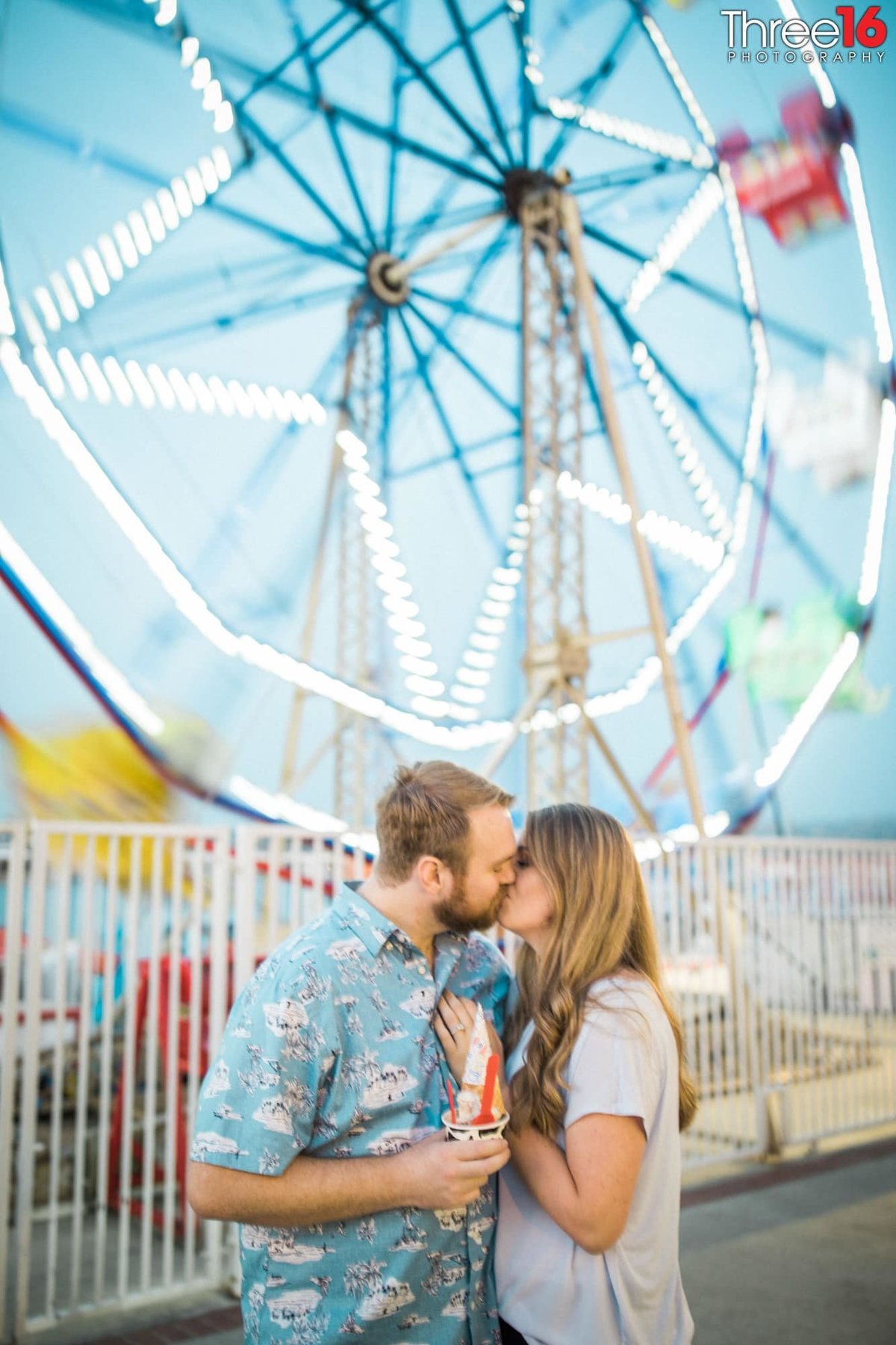 Tender kiss in front of the Balboa Fun Zone Ferris Wheel