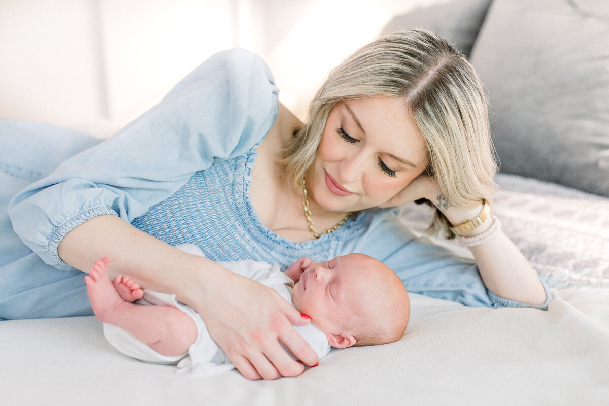 Alpharetta newborn photographer- mom and baby on bed