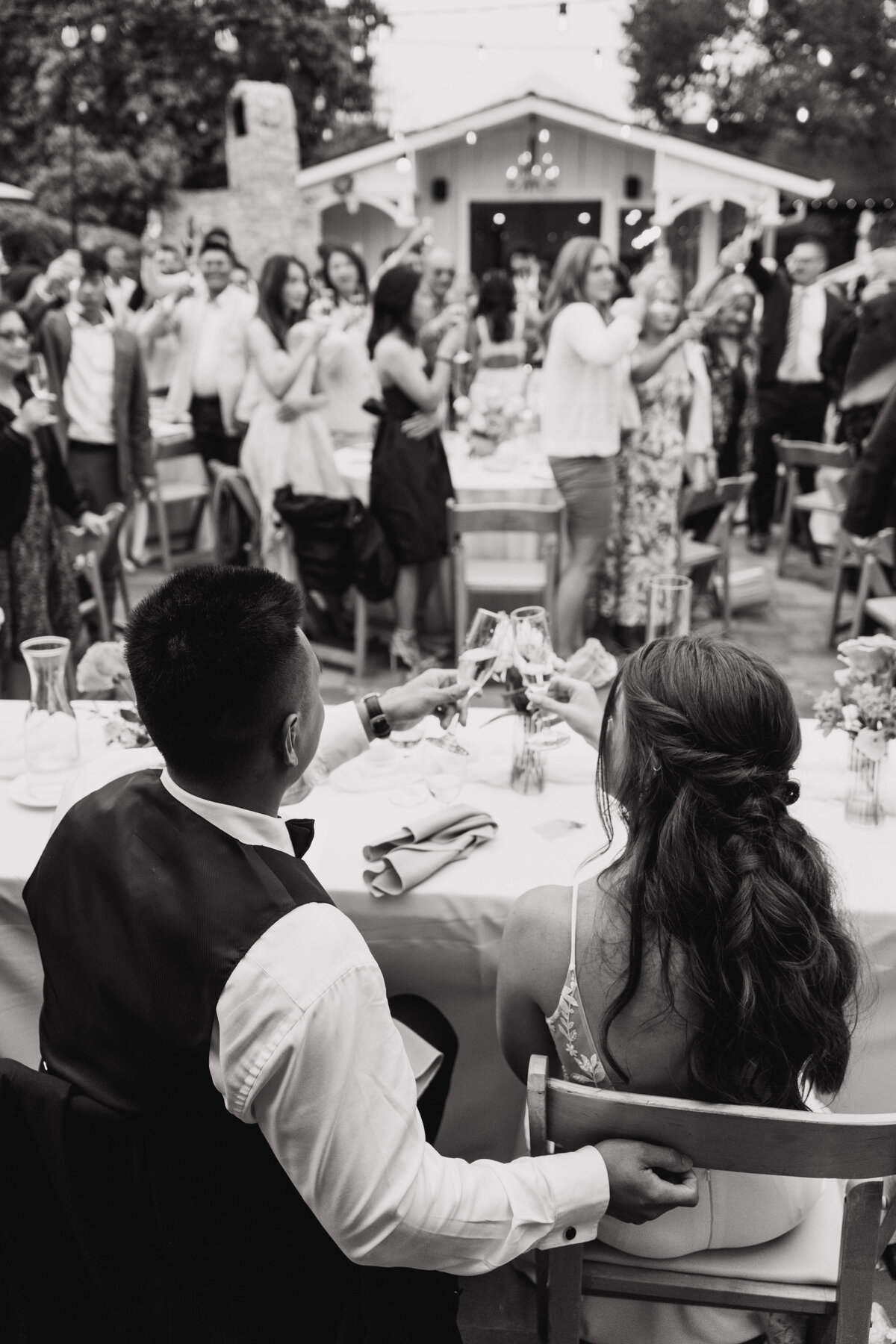 bride and groom raise glasses on wedding day